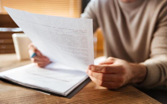 Un hombre consulta un contrato laboral