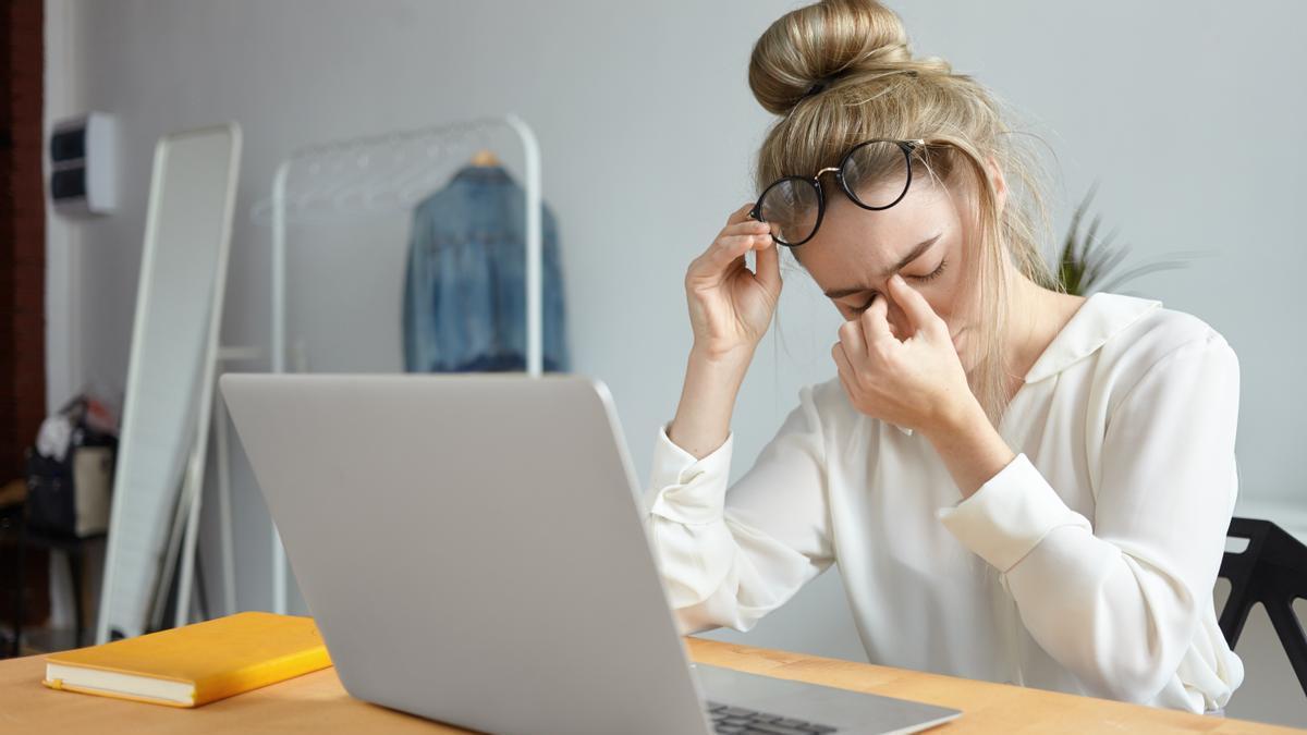 Mujer con dificultad para concentrarse mientras realiza tareas en el ordenador