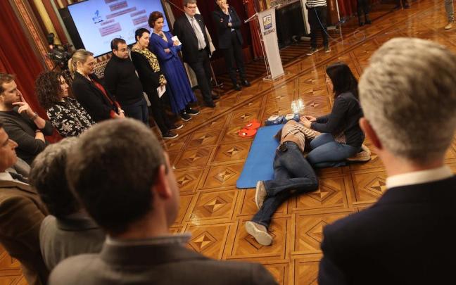 Corporativos municipales atienden a la demostración práctica de una RCP efectuada por Marina Etxebarrieta y Mónica Ariz, médica y enfermera respectivamente del Área de Salud.