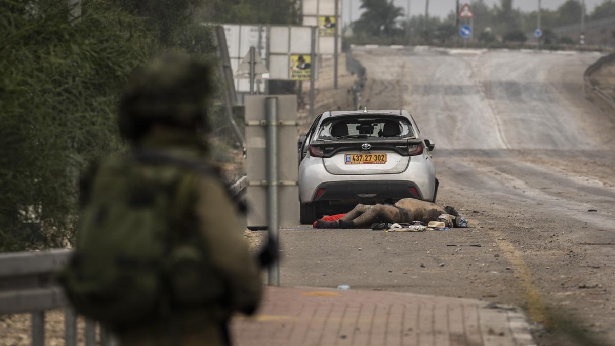 Un cuerpo yace en una carretera mientras las fuerzas israelíes patrullan las regiones a lo largo de la frontera entre Israel y Gaza.