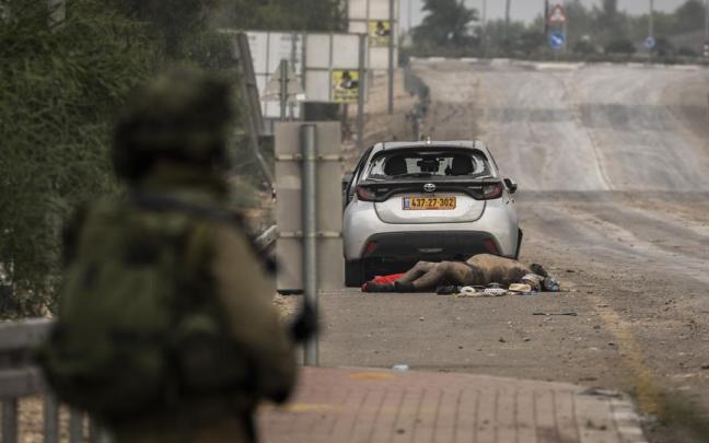Un cuerpo yace en una carretera mientras las fuerzas israelíes patrullan las regiones a lo largo de la frontera entre Israel y Gaza.
