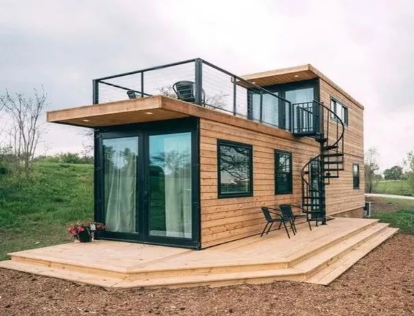 Casa prefabricada con dos alturas y terraza en el piso superior.