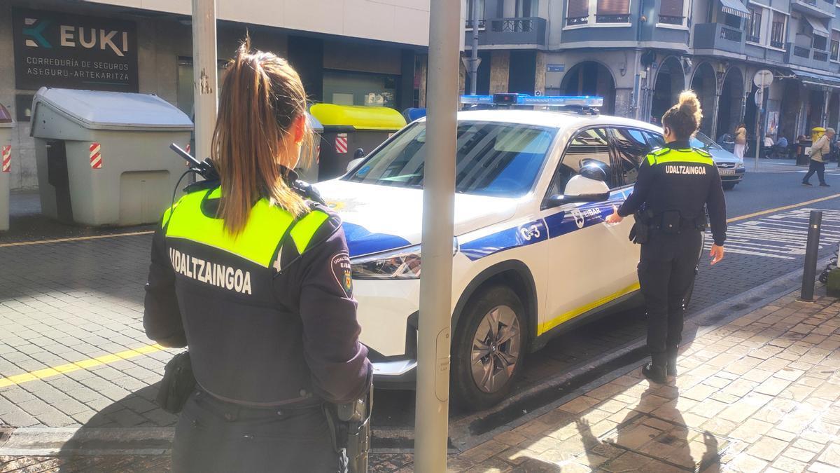 Dos agentes de la Policía Municipal de la villa armera se dirigen al coche estacionado junto a la casa consistorial.