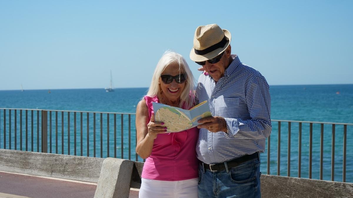 Dos pensionistas consultan un mapa durante un viaje del Imserso.