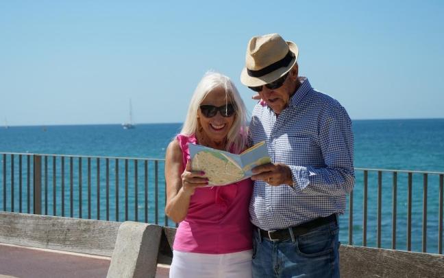 Dos pensionistas consultan un mapa durante un viaje del Imserso.