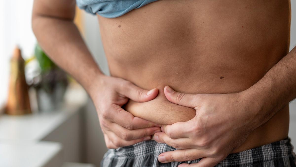 Hombre agarrándose la tripa.