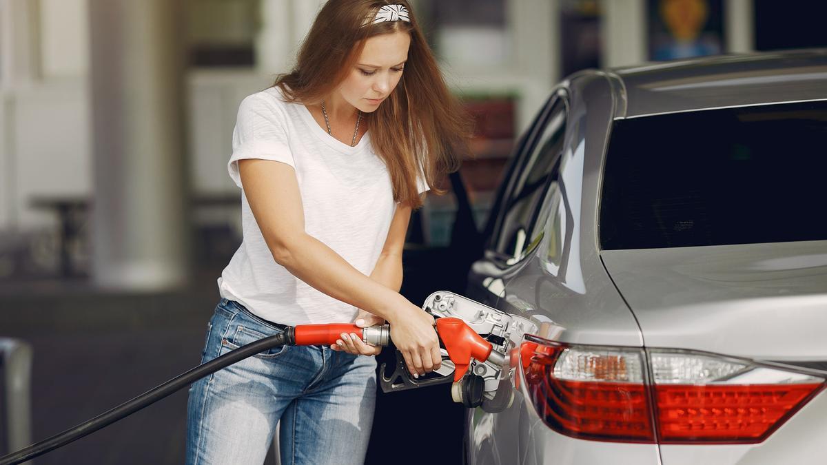 Una mujer llena el depósito de su vehículo en una gasolinera.