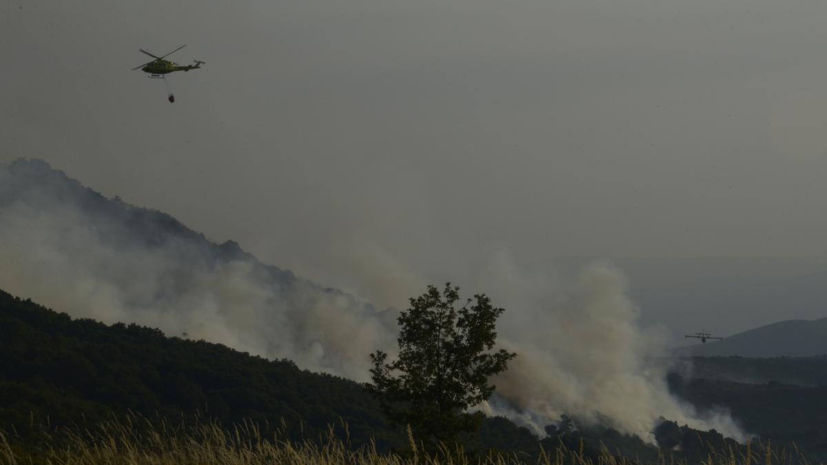 Un helicóptero tira agua sobre el fuego para extinguir el incendio