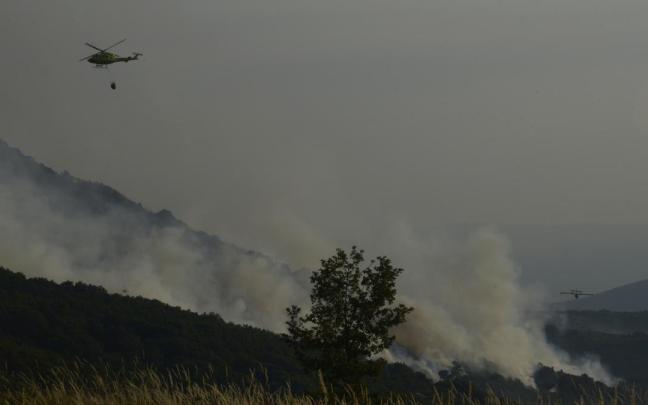 Un helicóptero tira agua sobre el fuego para extinguir el incendio