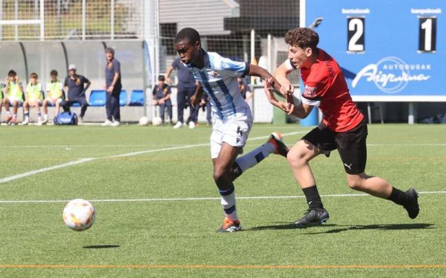 Alfredo Alogo corre perseguido por un rival del Antiguoko, durante el partido de este domingo. / IKER AZURMENDI