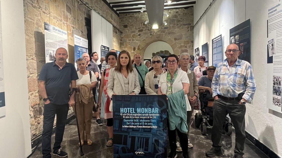 La consejera María Jesús San José, víctimas del GAL y familiares posan en la inauguración de la exposición