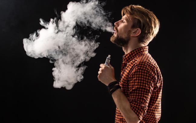 Hombre echando humo después de vapear.