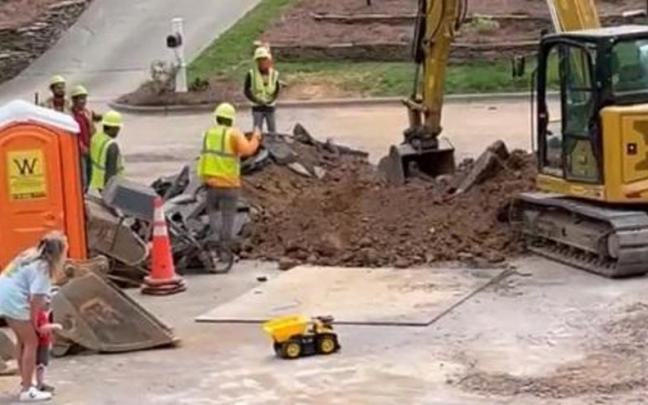 Los obreros, la madre, el niño y el camión de juguete.