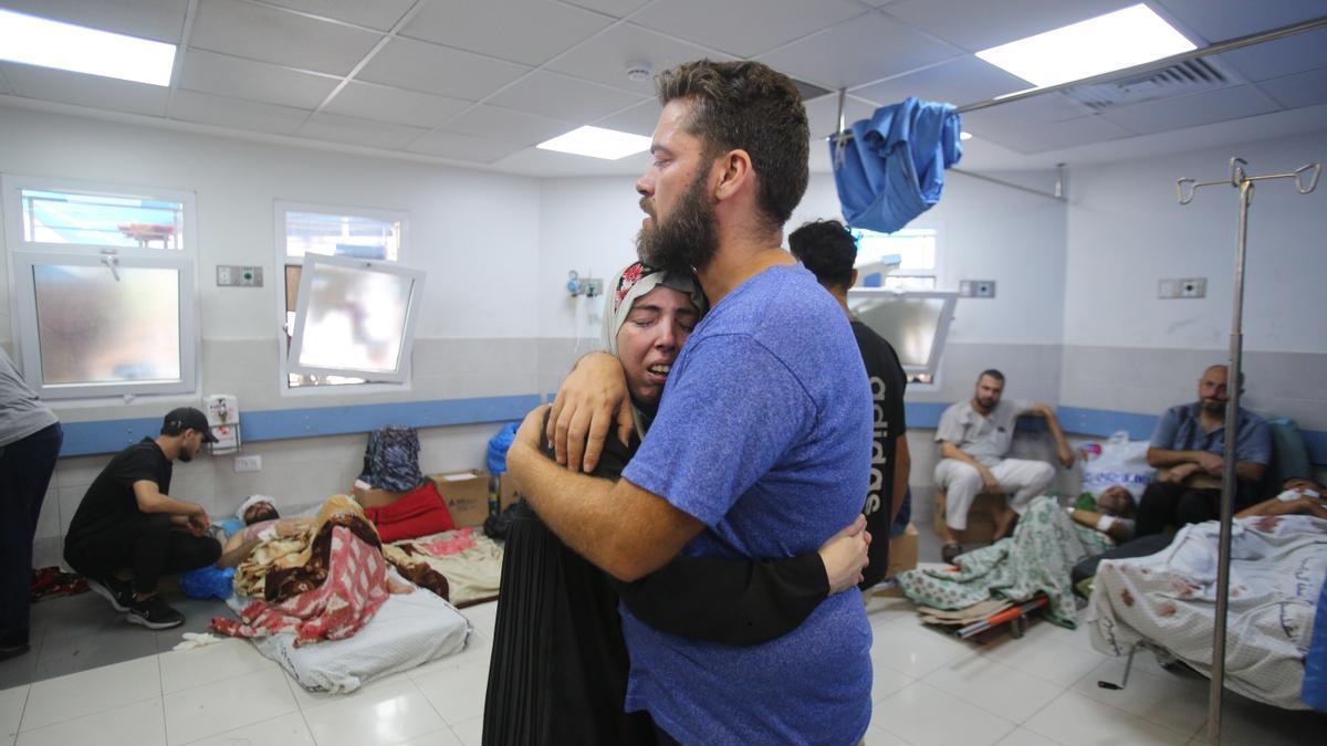 Dios personas se abrazan en el hospital de Al-Shifa tras un bombardeo israelí.