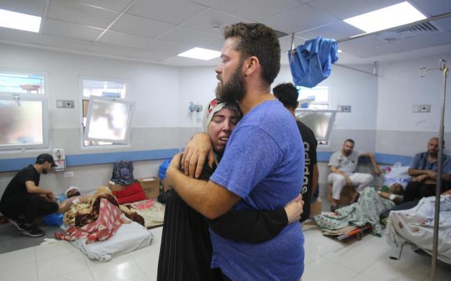 Dios personas se abrazan en el hospital de Al-Shifa tras un bombardeo israelí.