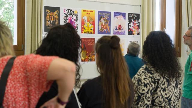 Miembros de la Comisión de Fiestas de Hernani observando los carteles