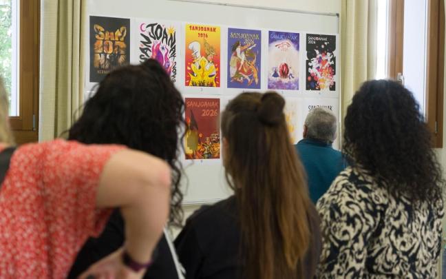 Miembros de la Comisión de Fiestas de Hernani observando los carteles