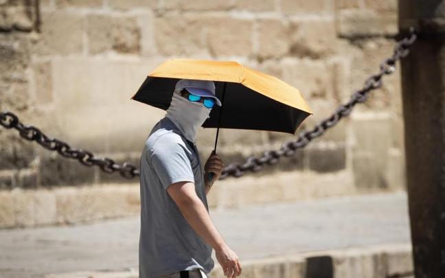 Un turista se protege del sol durante una de calor a finales del pasado mayo en Sevilla.