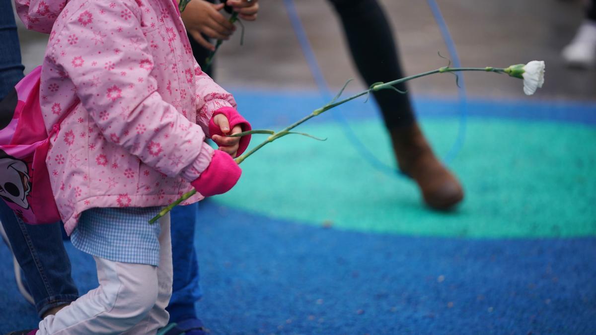 Imagen de archivo de un niño con una flor en un parque.
