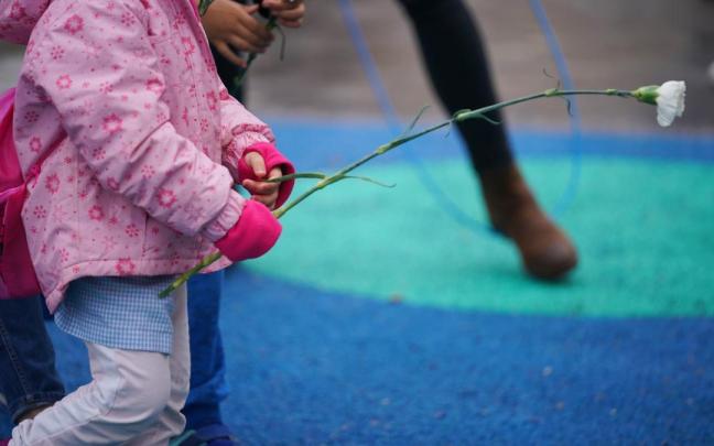Imagen de archivo de un niño con una flor en un parque.