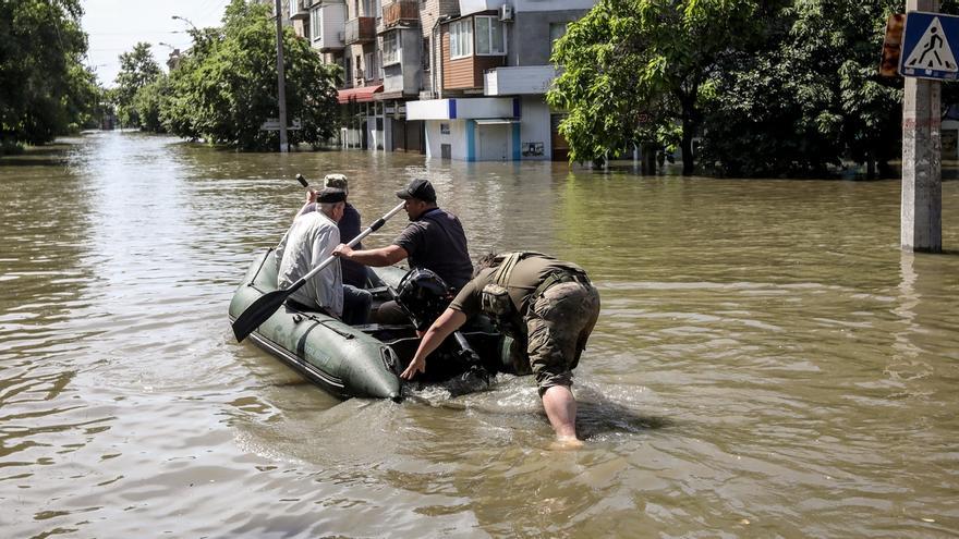 Un grupo de personas son trasladadas en una barca en una calle inundada de Jersón tras la destrucción de la presa.