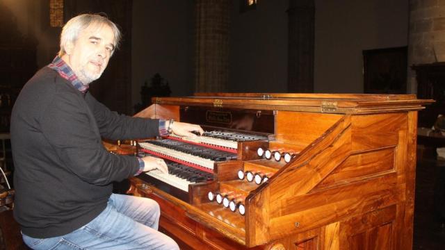 El organista titular de la parroquia de San Pedro junto al magnífico instrumento que hace sonar.