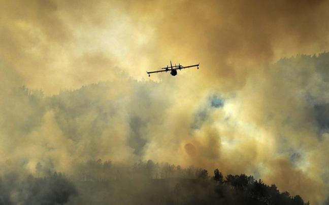 Un hidroavión realiza tareas de extinción en el incendio de Las Regueras (Asturias).