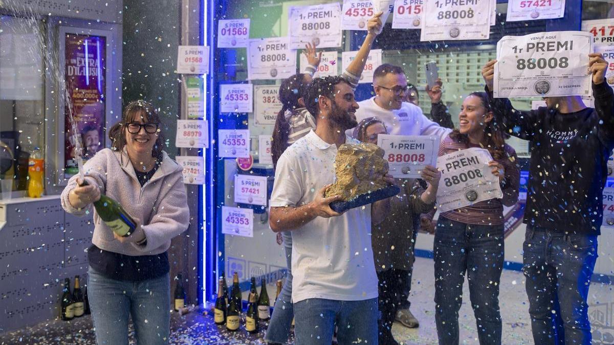Agraciados con el ‘Primer Premio’ del Sorteo Extraordinario de Lotería de Navidad 2023 correspondiente al número 88088 celebran su suerte en la administración donde compraron sus décimos