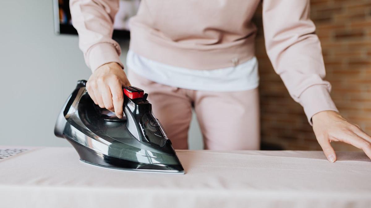 Una persona plancha sus prendas de ropa Pexels