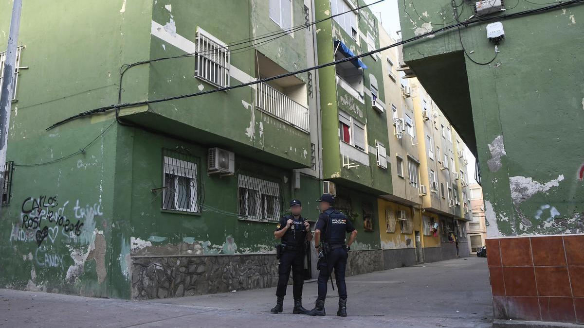 Miembros de la Policía Nacional realizan un cordón policial frente a la vivienda de la joven asesinada en Almería.