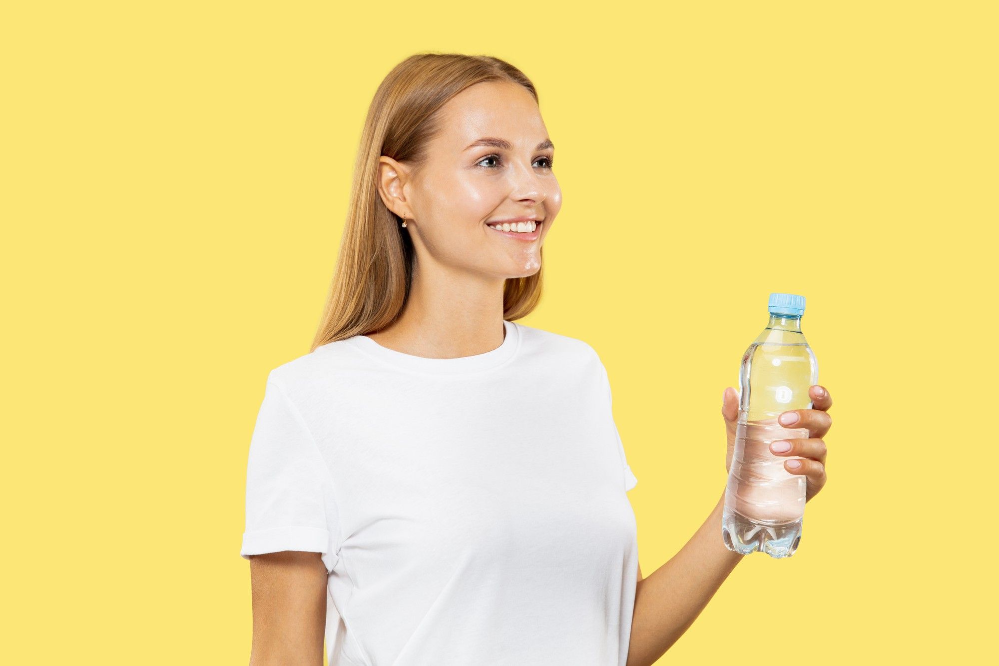Una mujer sostiene en su mano un botellín de agua.