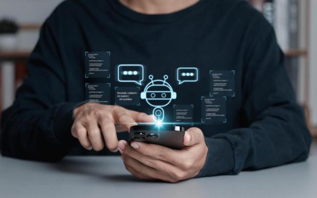 Un hombre conversa con un chatbot en su móvil.