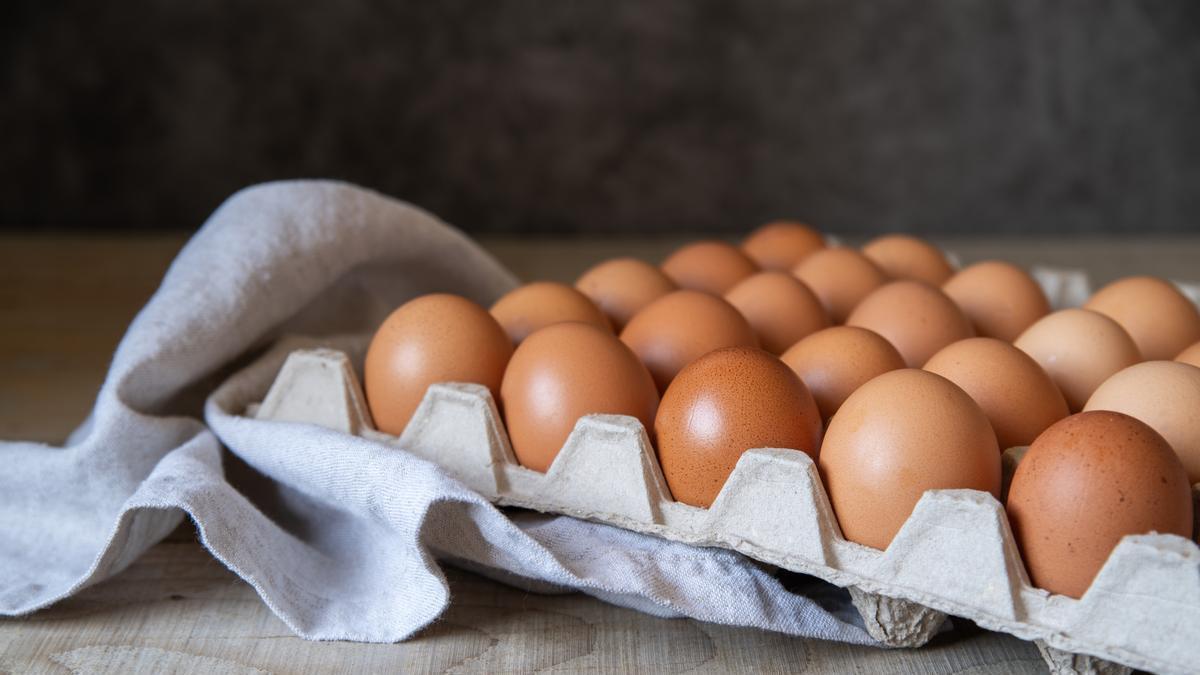 Caja de huevos encima de una mesa de madera.