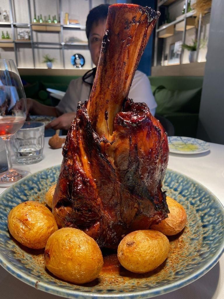 Jarrete acompañado de patatas.