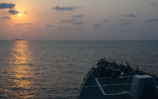 El destructor de misiles guiados USS Pinckney (DDG 91) observa un buque mercante mientras patrulla esta semana el estrecho de Ormuz.