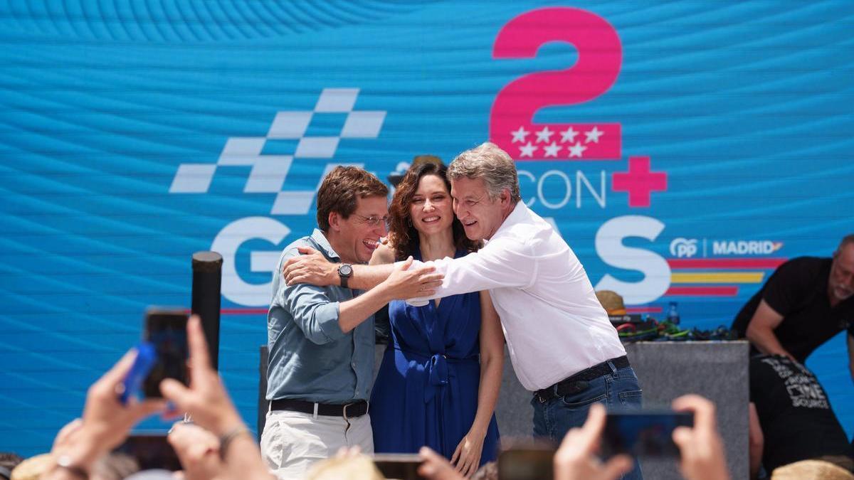 Ayuso se funde en un abrazo con Feijóo y Martínez-Almeida durante el acto celebrado en Madrid.