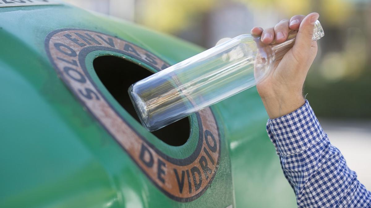 Un hombre tira una botella de vidrio.