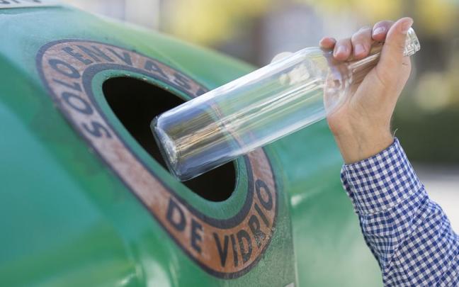 Un hombre tira una botella de vidrio.