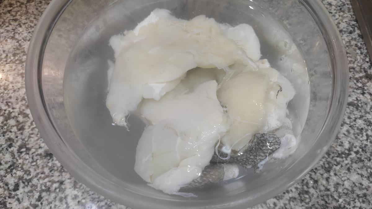 Recortes de bacalao en un bol con agua para desalarlos.