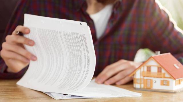 Una persona durante la lectura y posterior firma de un contrato de arras