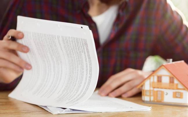 Una persona durante la lectura y posterior firma de un contrato de arras