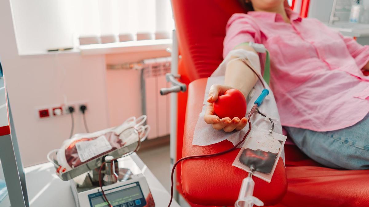 Una mujer dona sangre en un centro dependiente de un banco de sangre.