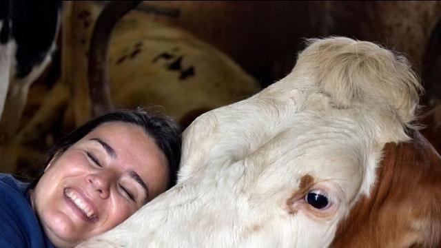 Sandra Aras se abraza a una de sus vacas.