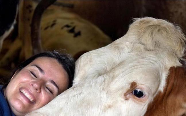 Sandra Aras se abraza a una de sus vacas.