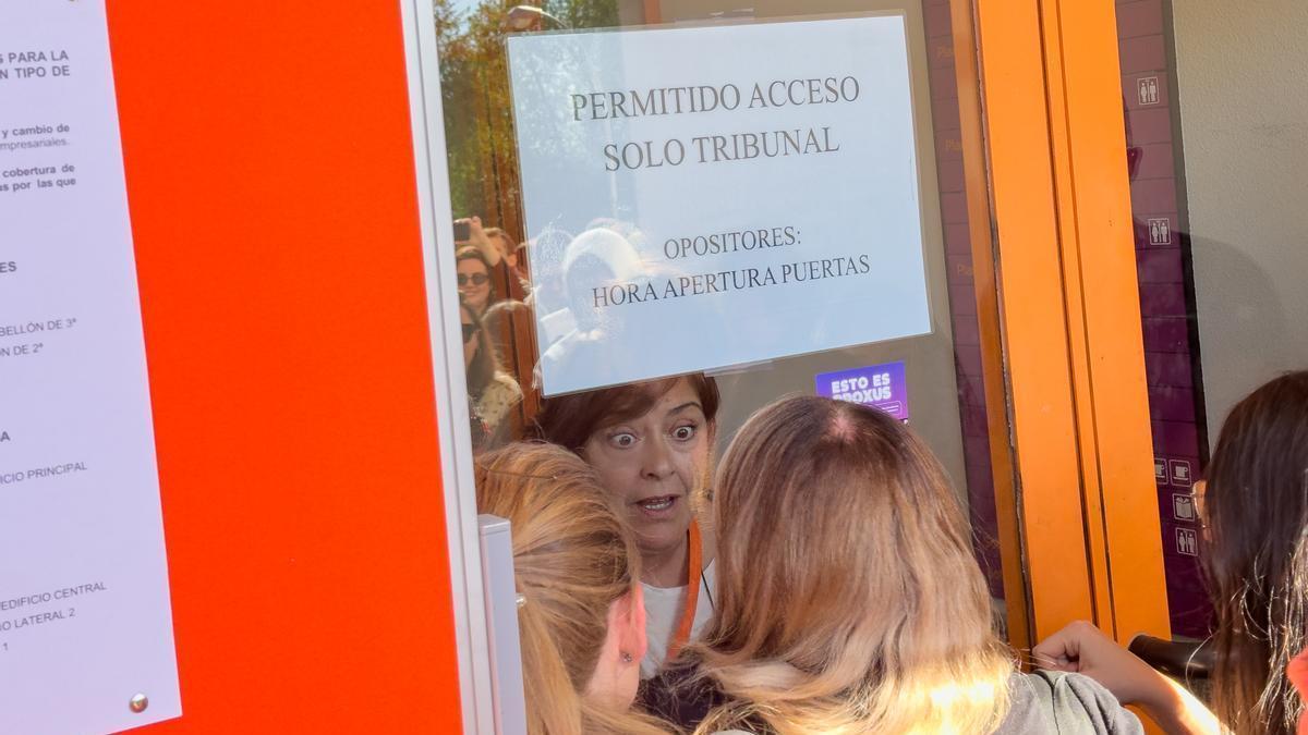 Opositores conversan con un examinador a la entrada del campus de Somosaguas tras el anuncio de la suspensión de los exámenes de oposición de RTVE.