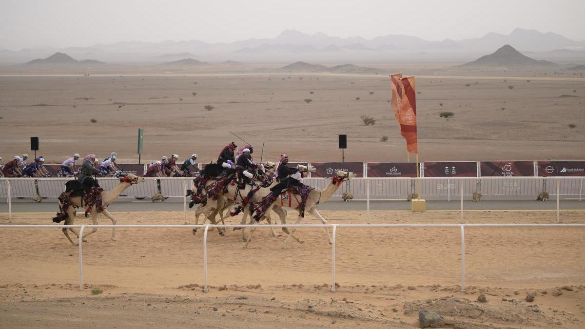 Los ciclistas ruedan en paralelo al circuito de las carreras de dromedarios.