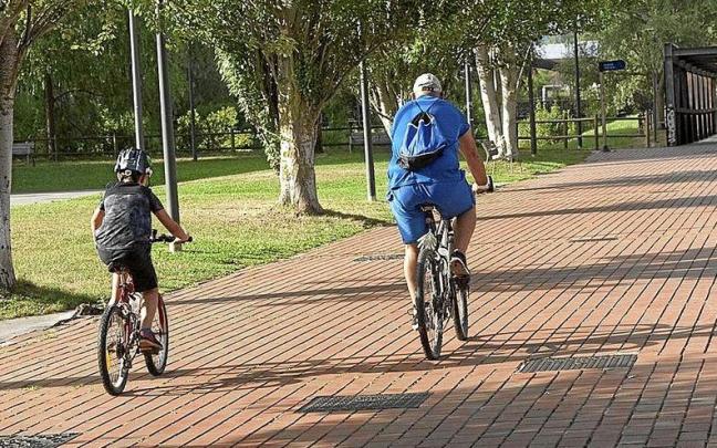 Un niño junto a su padre pasea en bicicleta por un parque de Zabalgana. Un niño junto a su padre pasea en bicicleta por un parque de Zabalgana.