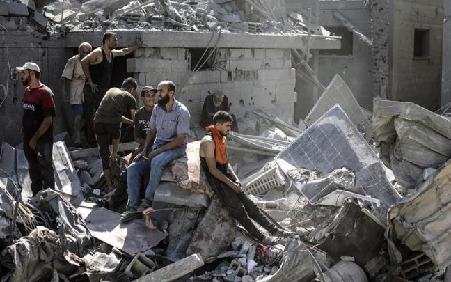 Ciudadanos palestinos entre los escombros de un edificio atacado en Gaza / EFE Ciudadanos palestinos entre los escombros de un edificio atacado en Gaza