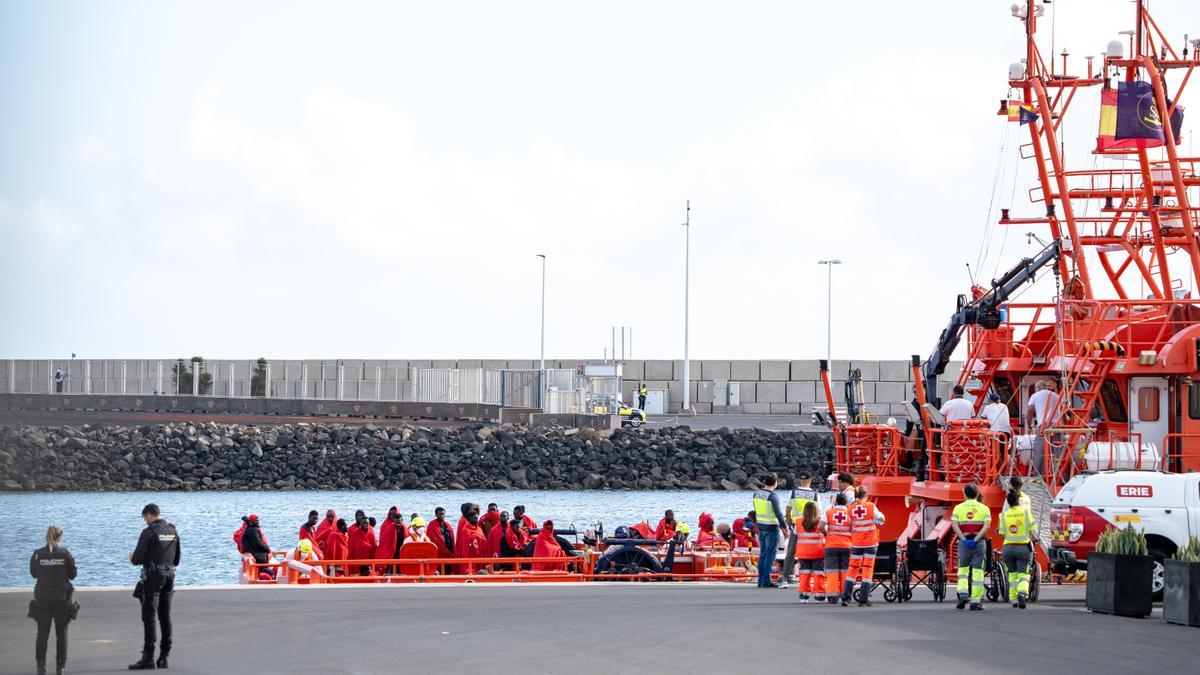 Agentes de los equipos de emergencia atienden a los migrantes en el muelle de Arrecife