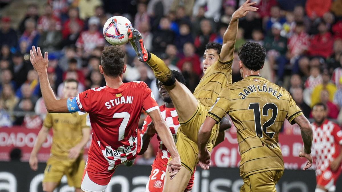 Aguerd despeja un balón ante el delantero del Girona Stuani, en presencia de Javi López. / DAVID BORRAT